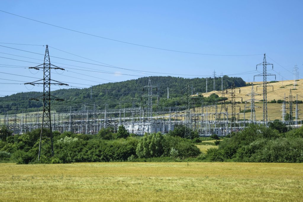 Electric transmission towers against a rural landscape, showcasing energy infrastructure.